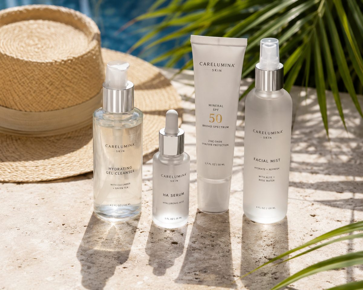 A Dallas summer skincare lineup on a travertine ledge by a pool: a hydrating gel cleanser, a hyaluronic-acid serum dropper, a tube of broad-spectrum mineral SPF 50, and a facial mist, beside a wide-brim straw hat with palm-leaf shadows falling across the stone.